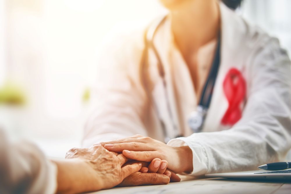 Doctor wearing pink ribbon comforting patient