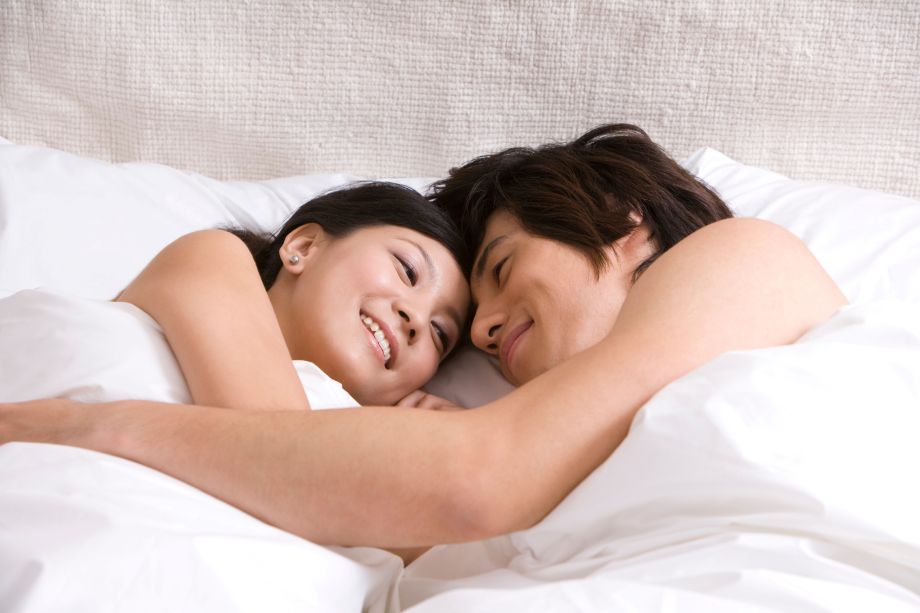 Couple lying in bed, cuddling