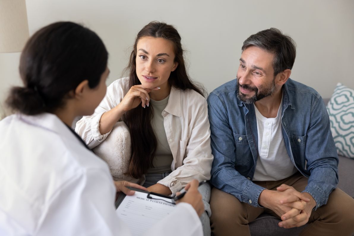 man and woman speaking with doctor