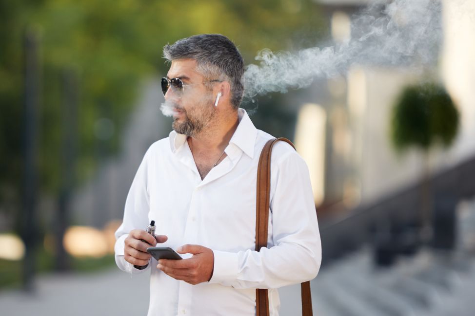 Older man smoking e-cigarette