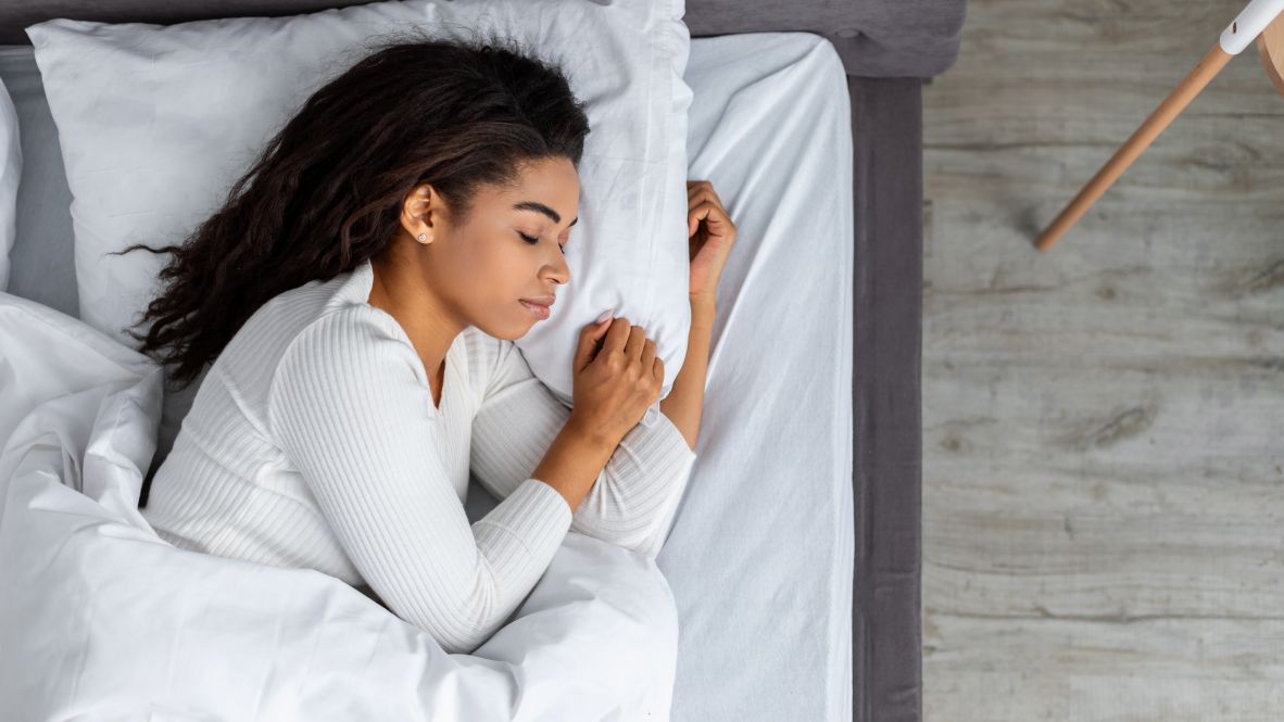 woman sleeping on side hugging pillow