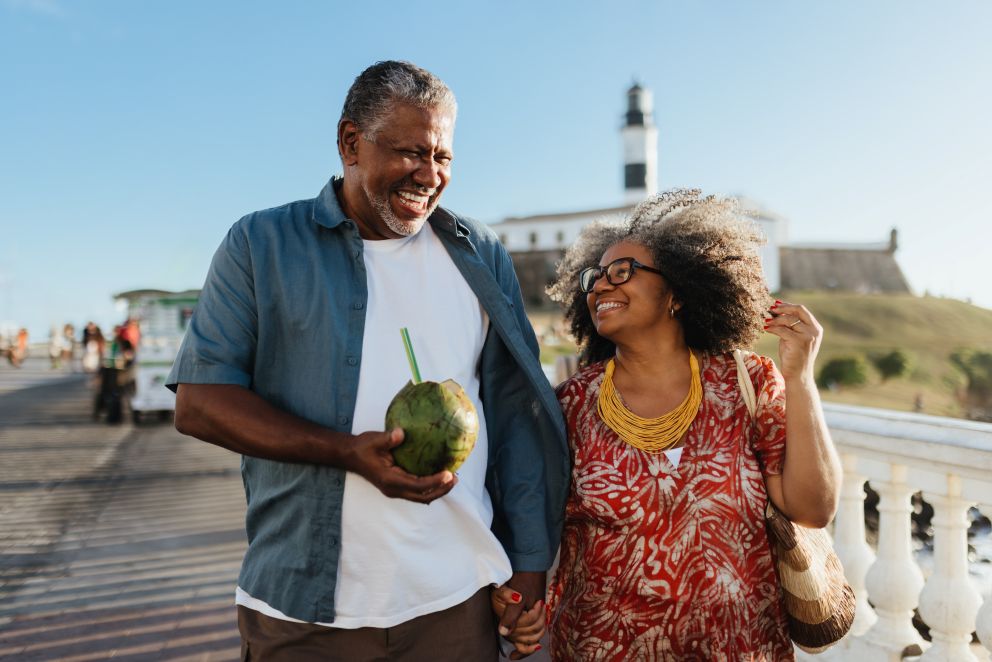 older couple walking on a pier, looking lovingly at each other