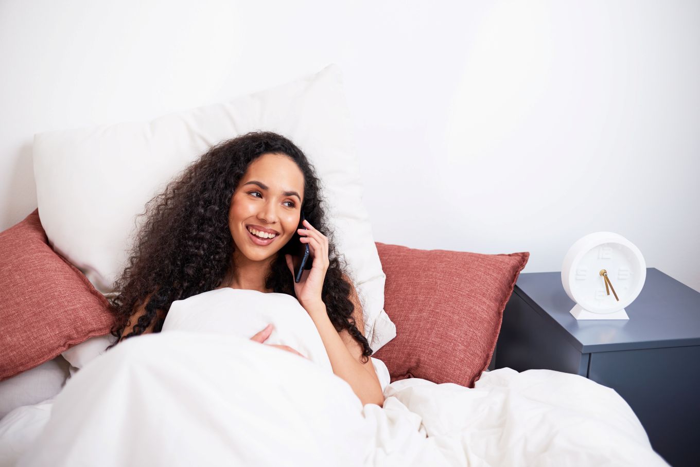 woman talking on the phone in bed