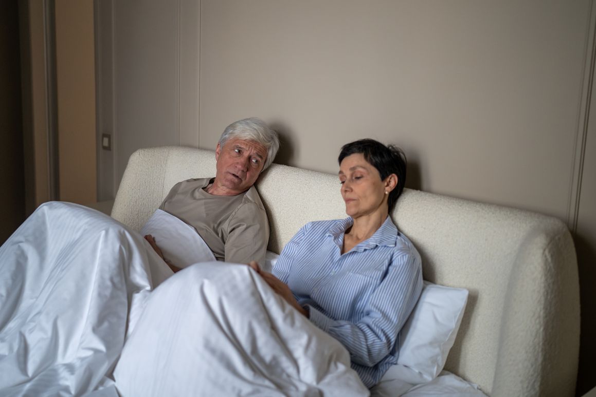 man and woman sitting in bed together